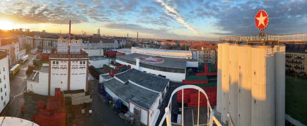 The Sternburg brewery with a view over Leipzig in the background. The sun is setting on the horizon.